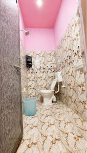 a bathroom with a toilet and a pink ceiling at Hotel BABA DEEP SINGH RESTAURANT AND ROOMS in Ahmedabad