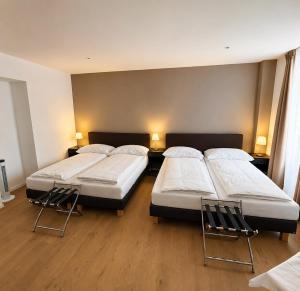 two beds in a room with two chairs at Hotel Splendid in Montreux
