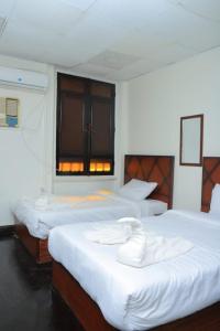 a bedroom with three beds with white sheets and a window at Kings palace castle in Cairo +75 photos