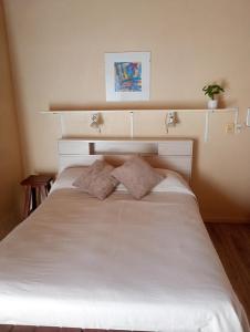 a bed with two pillows on it in a room at Lavandula in Villa Elisa