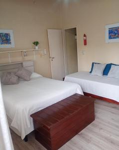 a room with two beds and a bench in it at Lavandula in Villa Elisa