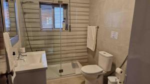 a bathroom with a toilet and a sink and a shower at Vivenda Alves in Charneca +22 photos