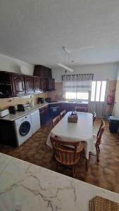 a kitchen with a table and chairs in a room at Vivenda Alves in Charneca