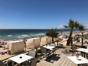 a beach with tables and chairs and the ocean at Vivenda Alves in Charneca