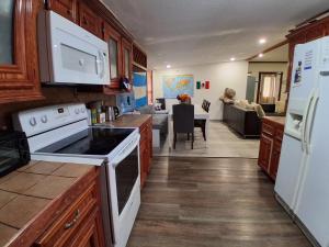 a kitchen with white appliances and a living room at Alojamiento Los Andes in Brownsville