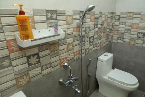 a bathroom with a toilet and a sink with tiles at NJ Grand Villa in Kālapettai +84 photos