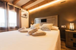 a bedroom with a large bed with white sheets and pillows at Casa Rural LA COSTANILLA in Lituénigo
