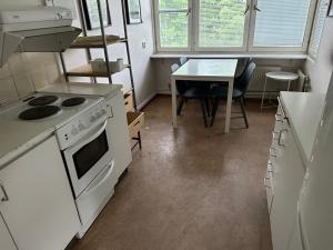 a kitchen with a stove and a table with chairs at Apartment in Skarholmen Stockholm 206 in Stockholm