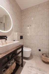 a bathroom with a sink and a toilet and a mirror at Doma in Supetar
