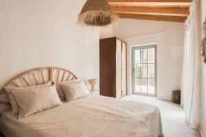 a white bedroom with a large bed and a window at Doma in Supetar