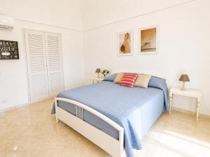 a white bedroom with a bed and two tables at Maridea - Turritella in Ponza