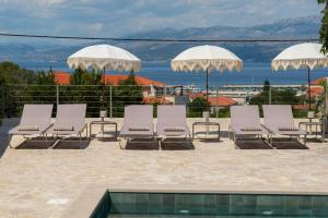 a group of chairs and umbrellas next to a pool at Doma in Supetar +63 photos