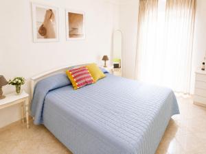 a white bedroom with a bed with a blue blanket at Maridea - Turritella in Ponza