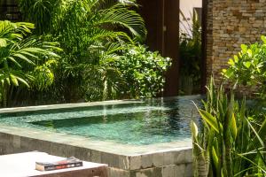 a swimming pool in a garden with plants at Villa Alegria - La Villa Group in Jericoacoara