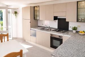 a kitchen with white cabinets and a sink and a table at Maridea - Turritella in Ponza +6 photos