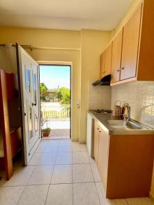a kitchen with a sink and an open door at Nomads in the south in Tsoutsouros +25 photos