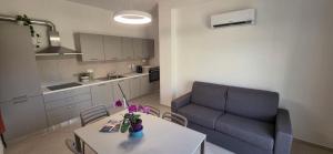 a living room with a table and a blue couch at Bardia Guest House in Dorgali