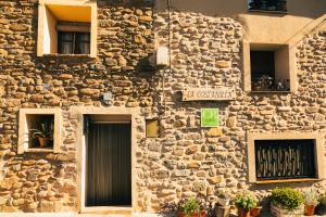 a stone building with a door and a sign on it at Casa Rural LA COSTANILLA in Lituénigo