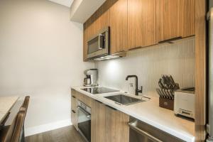 a kitchen with a sink and a microwave at Kindred Resort, A RockResort in Keystone