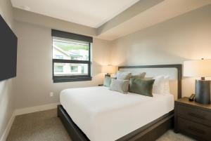 a bedroom with a white bed and a window at Kindred Resort, A RockResort in Keystone +228 photos