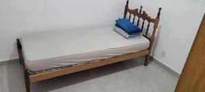 a small bed with a blue pillow on it at Lar Tranquilo Com Garagem in Pirassununga +17 photos