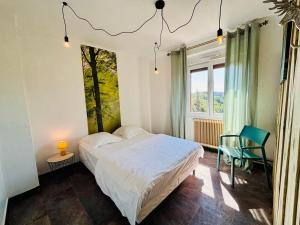 a bedroom with a bed and a chair and a window at Logis Hôtel-Restaurant Aux Trois Roses in La Petite-Pierre +45 photos