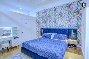 a bedroom with a blue bed and a colorful wall at The Stallion #101 - 1BD Modern Loft with Private Patio - Walk to various attractions in Memphis