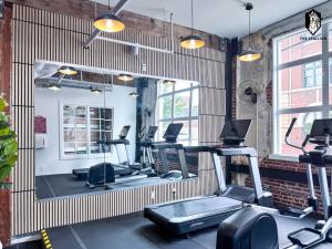 a gym with several treadmills and a mirror at The Stallion #101 - 1BD Modern Loft with Private Patio - Walk to various attractions in Memphis