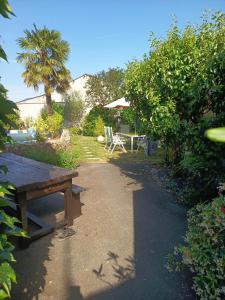 a picnic table and a bench in a garden at La Fleur de Lys in Moulins