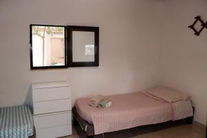 a bedroom with a bed and a dresser and a mirror at Pantera Rosa Village in Scalea +39 photos