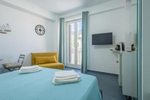 a room with a bed and a chair and a window at Le Isole di Anita in Lipari