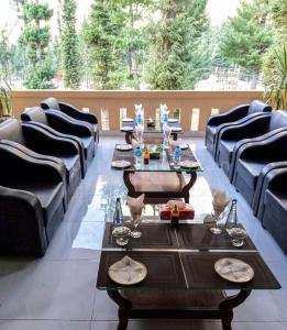a restaurant with couches and tables with glasses on them at Grand palace hotel kumrat in Tāl