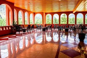 a large room with chairs and tables and windows at Grand palace hotel kumrat in Tāl