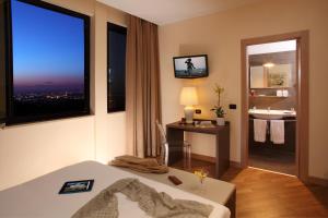 a hotel room with a bed and a view of a bathroom at Hotel & Spa Villa Mercede in Frascati