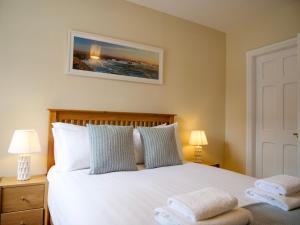 a bedroom with a white bed with two pillows at Central Dingle Cottage in Dingle