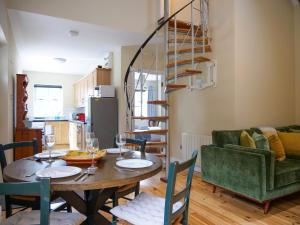 a dining room with a table and a green couch at Central Dingle Cottage in Dingle +22 photos