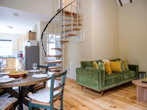 a living room with a green couch and a table at Central Dingle Cottage in Dingle