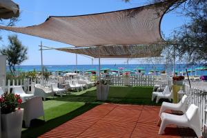 an outdoor wedding with white chairs and tables at Pantera Rosa Village in Scalea