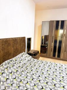 a bedroom with a large bed and a mirror at Le balcon bleu in Oran