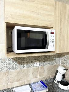 a microwave on a shelf in a kitchen at Le balcon bleu in Oran