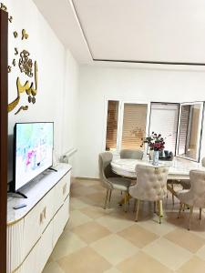 a living room with a dining table and a tv at Le balcon bleu in Oran +4 photos