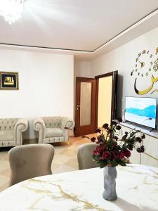 a living room with a table and chairs and a tv at Le balcon bleu in Oran