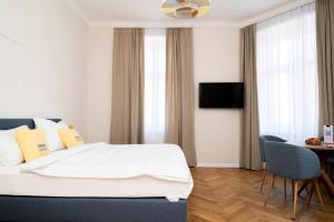 a hotel room with a bed and a table and chairs at Miki Stays - 200m zum Prater in Vienna