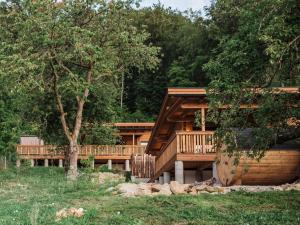 a log cabin with a deck in the woods at Romantikchalet Bärenhöhle mit eigenen Wellnessbereich, Komfort und viel Ruhe in Vorra
