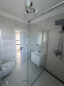 a white bathroom with a sink and a toilet at Geo rental properties in Rădăuţi