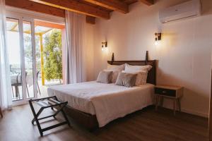 a bedroom with a bed and a large window at Casinhas de Santo António in Alter do Chão +46 photos