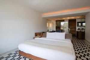 a bedroom with a large white bed and a kitchen at La Purificadora, Puebla, a Member of Design Hotels in Puebla +35 photos