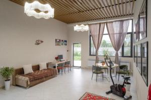 ein Wohnzimmer mit Sofa und einem Tisch mit Stühlen in der Unterkunft Vell7 Hotel in Dzhetyoguz