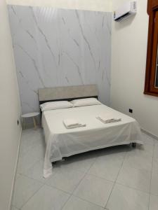 a bedroom with a bed with white sheets and pillows at Vittoria & Celeste in Cervino