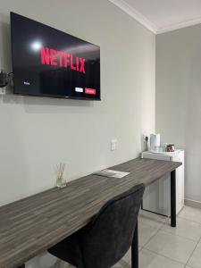 a tv on a wall with a netflix sign on it at Blooming Rose Bed and Breakfast in Polokwane